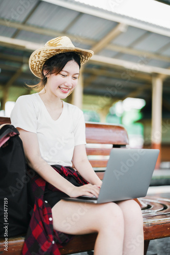 summer, relax, vacation, travel, portrait of beautiful Asian girl using the computer laptop at the train station while waiting for their travel time.