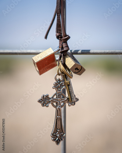 Vertical shot of locks and a cross in Marfa, Texas photo