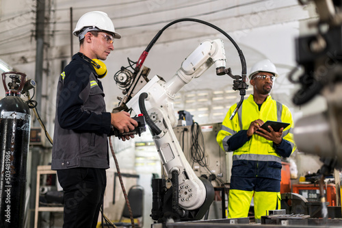 Robotics control engineers solve problems control panel of robot for setting programming for industrial robot arm controller in production plant factory