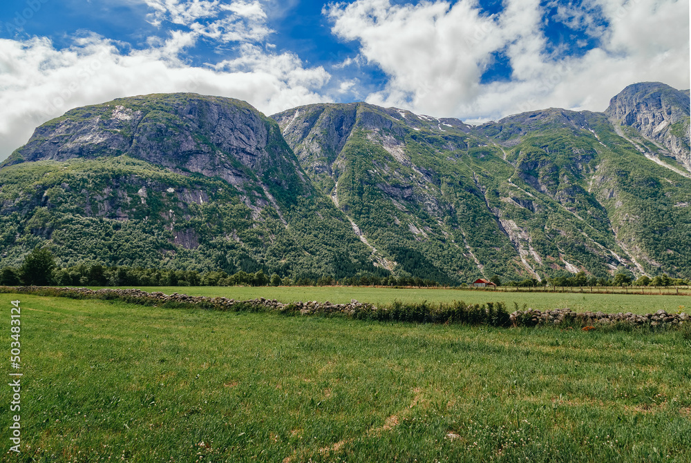 landscape with mountains. Green meadows with a high mountain backdrop on a sunny summer day, Eidfjord, Hordaland, Norway