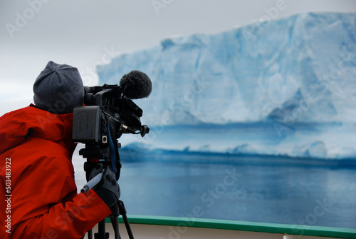 Photographer filming an iceberg