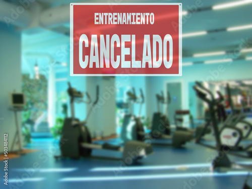 in Spanish inscription sorry workout canceled. gym restrictions during quarantine. Modern gym interior with equipment