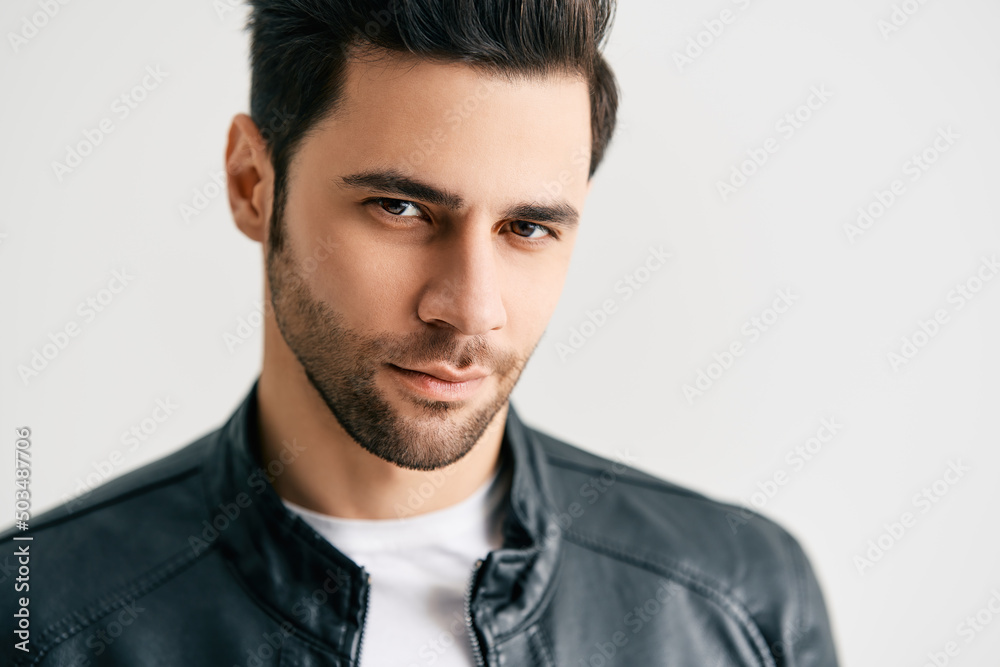 Closeup portrait of handsome trendy man posing on white studio background Closeup portrait of handsome trendy man posing on white studio background