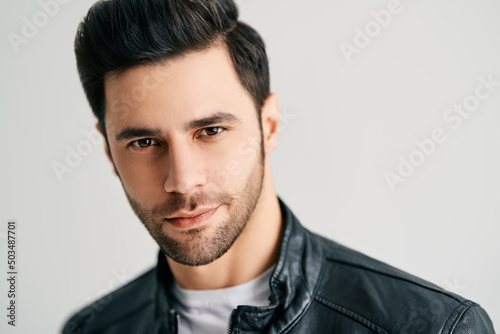 Closeup portrait of handsome trendy man posing on white studio background photo