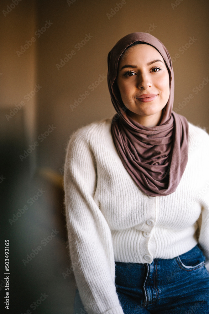 Portrait of smiling young woman wearing hijab at home Portrait of smiling young woman wearing hijab at home