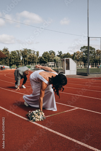 Bride in white sneakers. Lifestyle and casual. Wedding day. Bride in a white dress at the stadium.