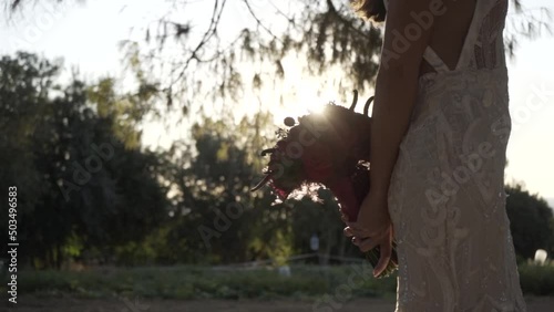 The bride holds her bouquet with both hands. photo