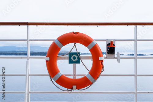 red life buoy. Ring life boy on big boat.Obligatory ship equipment. Orange lifesaver on the deck of a cruise ship. photo