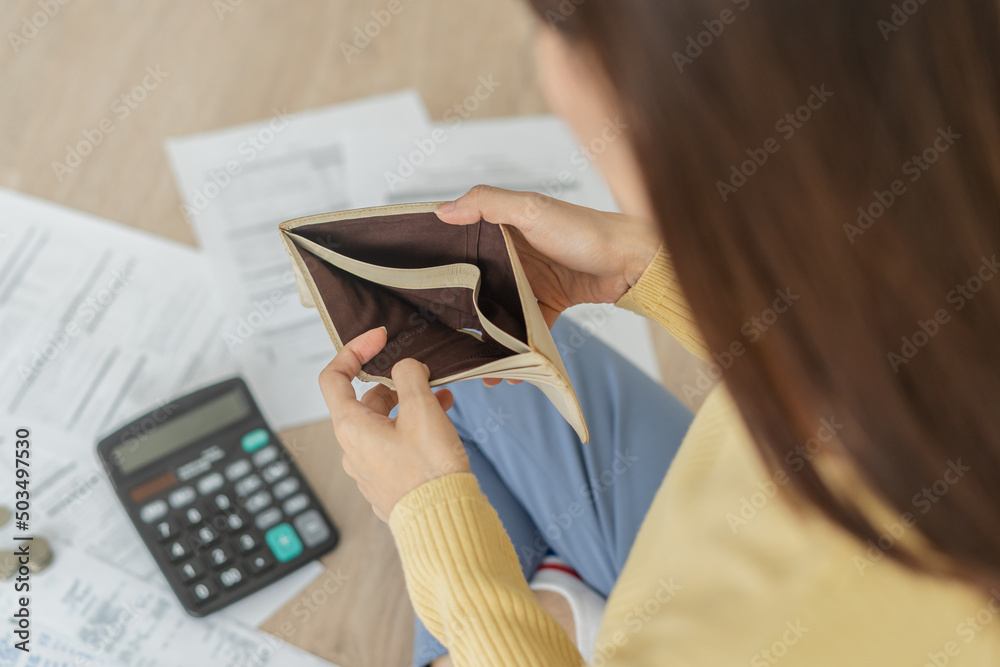 Obraz premium Top view owe asian woman, female sitting on floor stressed and confused by calculate expense from invoice or bill, have no money to pay, mortgage or loan. Debt, bankruptcy or bankrupt concept.