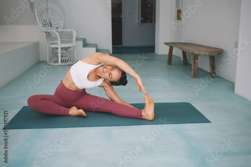 Caucasian girl practicing yoga at spacious home