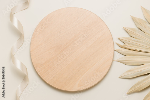 Round wooden desk or stand with palm leaf top view, podium for organic product and food presentation