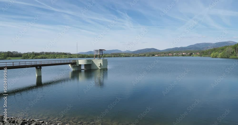 Le barrage de Michelbach et lac artificiel dans le Haut-Rhin en Alsace. Vue sur la retenue d'eau et la tour d'évacuation prise d'eau depuis la digue principale et la route de couronnement