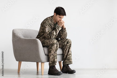 Depressed young military black covering his mouth with palms © Prostock-studio