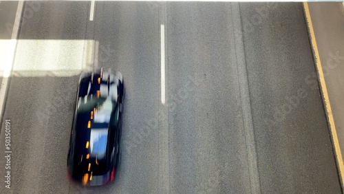 Photo of a blurred car driving down the road at high speed. Traffic camera shot. Lonely car on an asphalt road