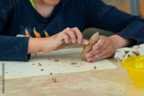 a child makes clay crafts with his hands