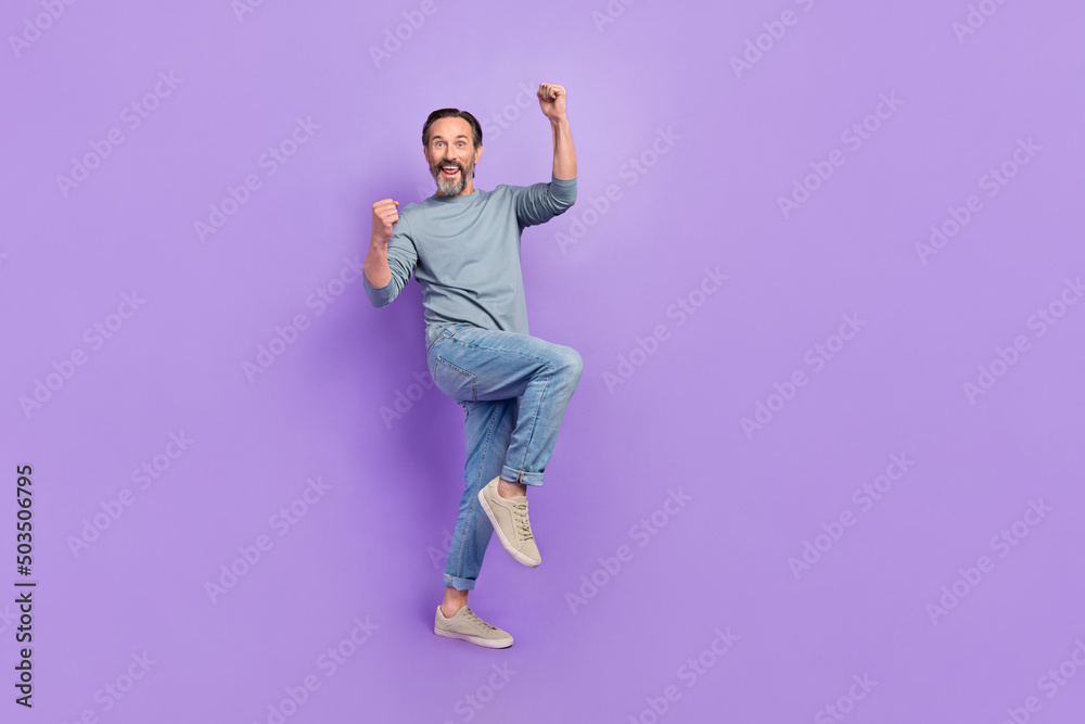 Full size photo of ecstatic overjoyed male raise fists in victory triumph win money prize isolated on purple color background