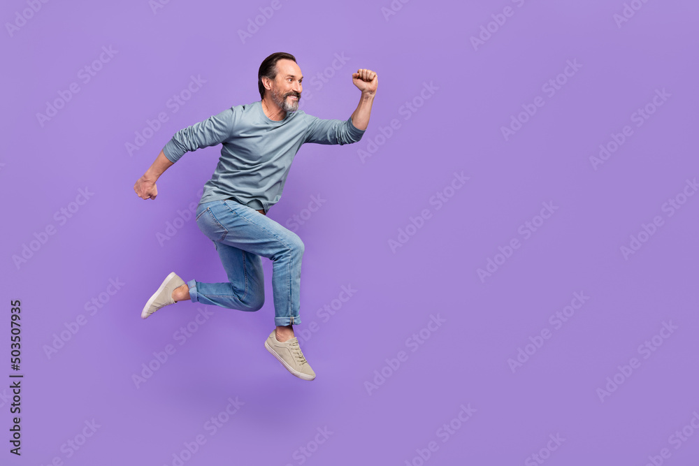 Full body profile side photo of mature man run jump hurry speed look empty space isolated over purple color background