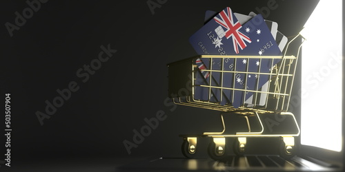 Credit card mockups with flags of Australia in a small shopping cart on the laptop. 3D rendering