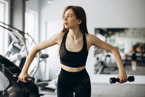 Woman lifting dumbbells at the gym