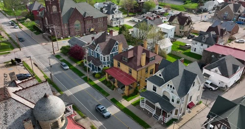 Historic mansions and homes along small town street. Aerial view in spring. Tilt up to reveal church and university campus. photo