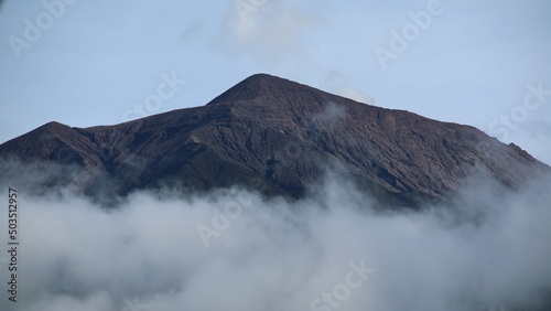 the peak of the volcano covered by white clouds