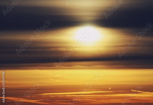 Atardecer dorado sobre la ciudad de Madrid en España. El sol tras unas frías nubes de finales de otoño creando un efecto distorsionador sobre la silueta del sol y el horizonte. © AngelLuis