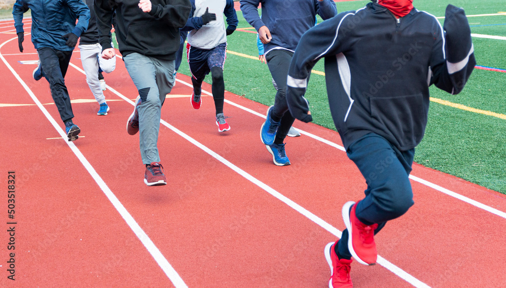 Naklejka premium Group of boys running on a track on a cold day