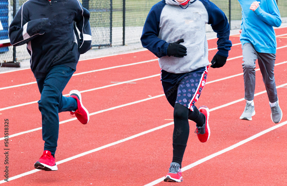 Fototapeta premium Young runners running on a track on a cold day