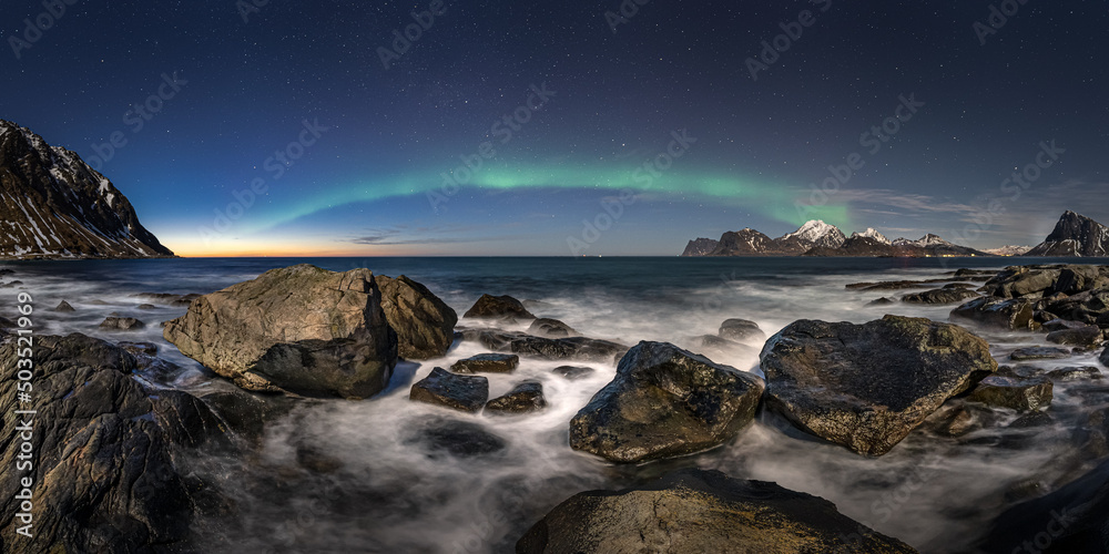 Naklejka premium Aurora over the sea at stone beach
