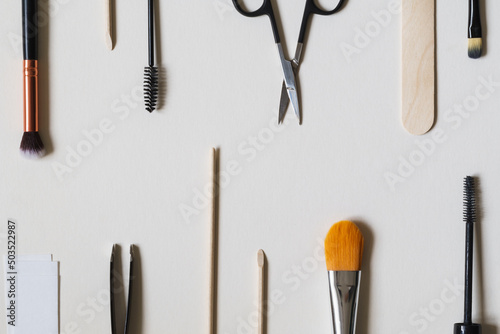 Beauty concept image including tools, products and equipment for tinting, waxing, facials and makeup beauty treatments. Neutral, black and white theme set against a white background with copy space.