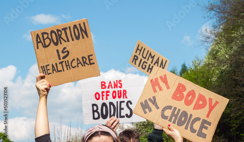 Protesters holding signs Abortion Is Healthcare, My Body My Choice, Bans Off Our Bodies, Human rights. People with placards supporting abortion rights at protest rally demonstration. © Longfin Media