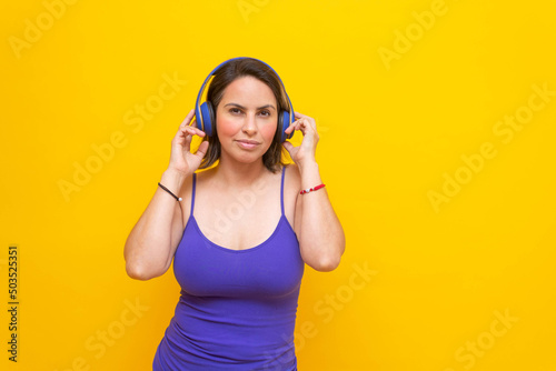 sexy middle aged mexican woman wearing headphones looking at camera smiling