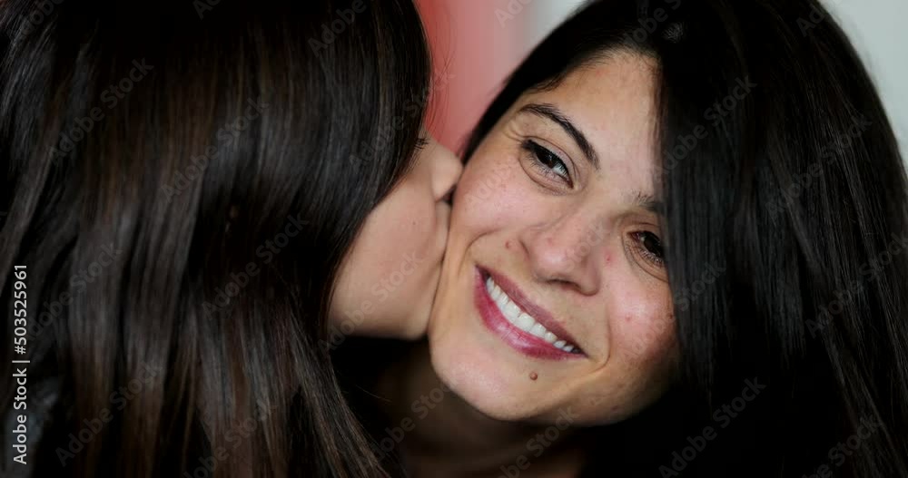 Daughter kissing mother on cheek mom and child love and affection