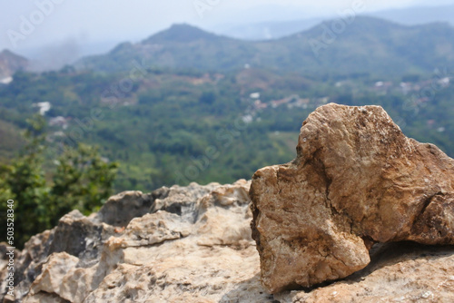 an ancient boulder on a rough rock against a mountain backdrop