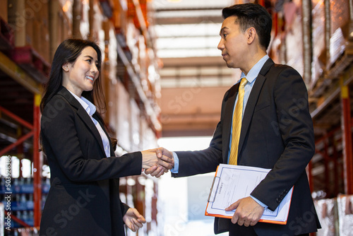 Billede på lærred Asian business woman shaking hand with men company manager or CEO for dealing contract agreement in warehouse production
