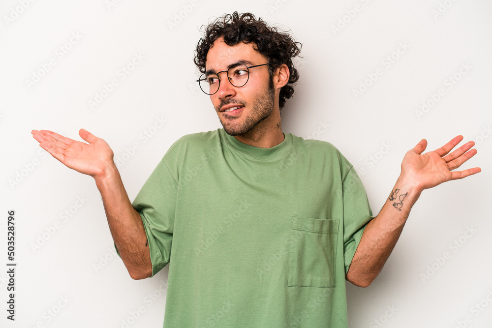 Young caucasian man isolated on white background confused and doubtful shrugging shoulders to hold a copy space. Young caucasian man isolated on white background confused and doubtful shrugging shoulders to hold a copy space.