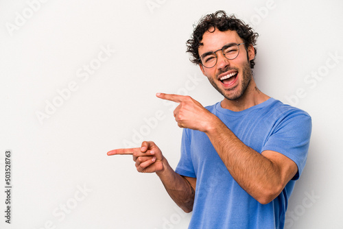 Young caucasian man isolated on white background excited pointing with forefingers away.