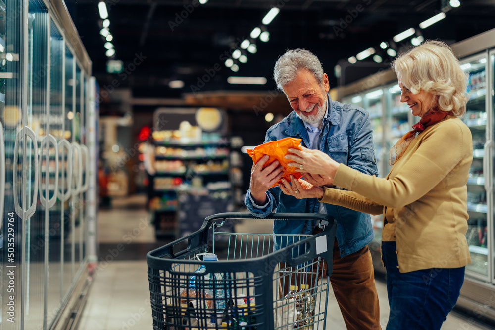 Senior couple at choosing products at the supermarket