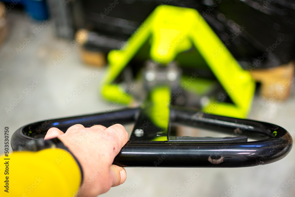 Forklift warehouse worker works with the hand pallet truck safely.