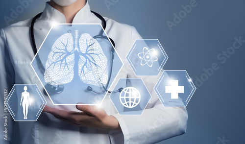 Unrecognizable female doctor holding graphic virtual visualization model of Lungs organ in hands. Multiple medical icons on the background. photo