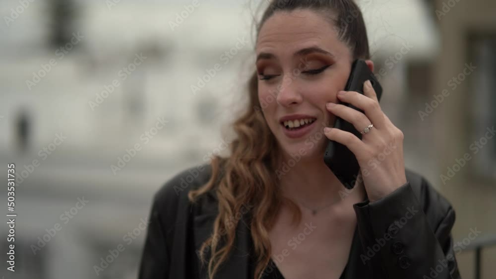 Chica joven delgada con pantalon y blusa negra con maleta de viaje en terraza de hotel Chica joven delgada con pantalon y blusa negra con maleta de viaje en terraza de hotel