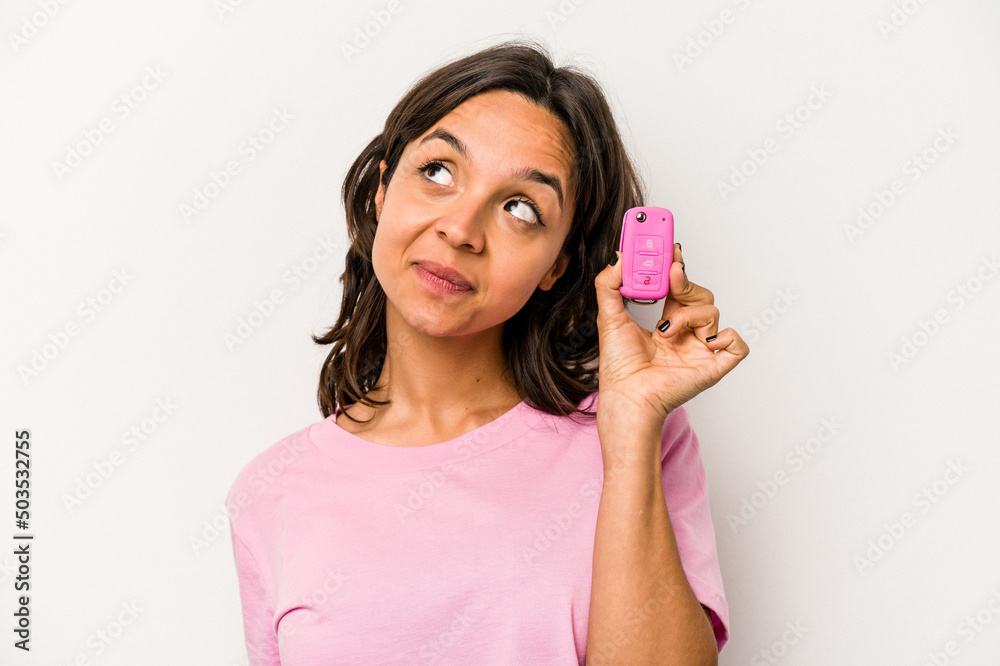 Young hispanic woman holding car keys isolated on white background dreaming of achieving goals and purposes Young hispanic woman holding car keys isolated on white background dreaming of achieving goals and purposes