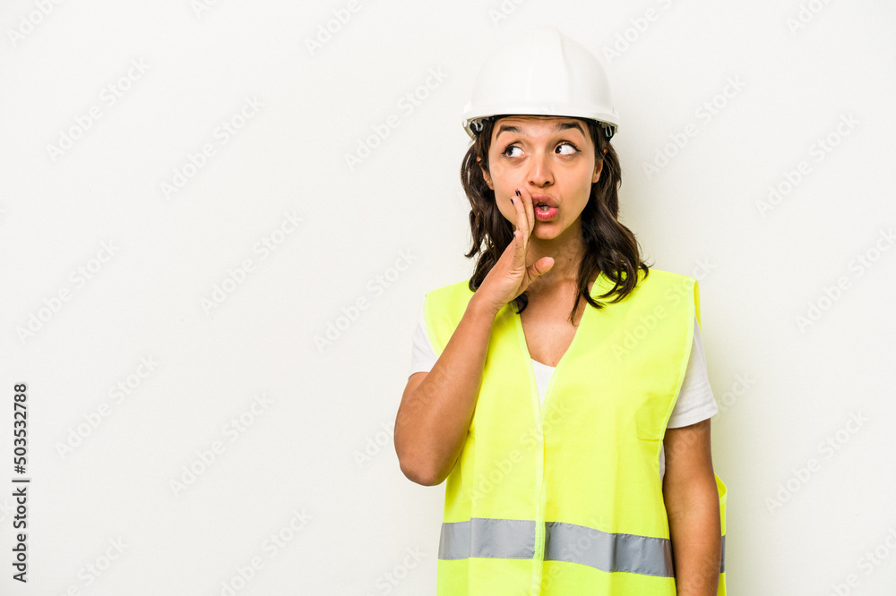 Young laborer hispanic woman isolated on white background is saying a secret hot braking news and looking aside Young laborer hispanic woman isolated on white background is saying a secret hot braking news and looking aside