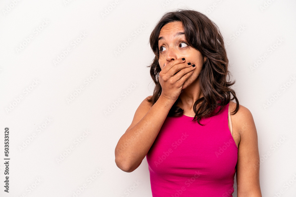 Young hispanic woman isolated on white background thoughtful looking to a copy space covering mouth with hand. Young hispanic woman isolated on white background thoughtful looking to a copy space covering mouth with hand.