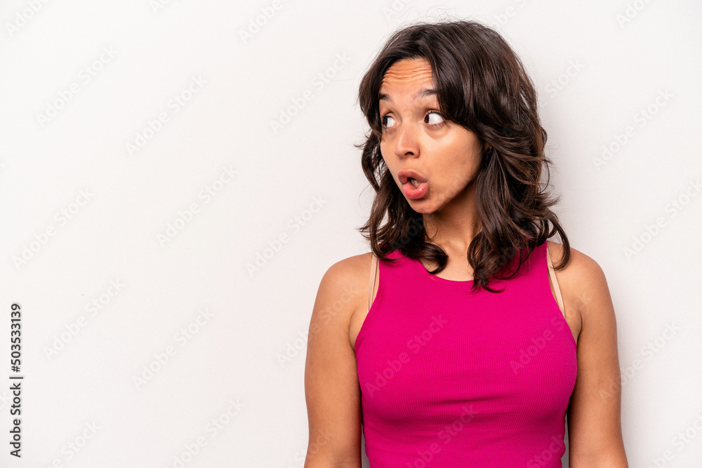 Young hispanic woman isolated on white background being shocked because of something she has seen. Young hispanic woman isolated on white background being shocked because of something she has seen.