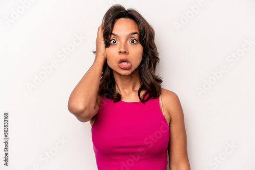 Young hispanic woman isolated on white background being shocked  she has remembered important meeting.