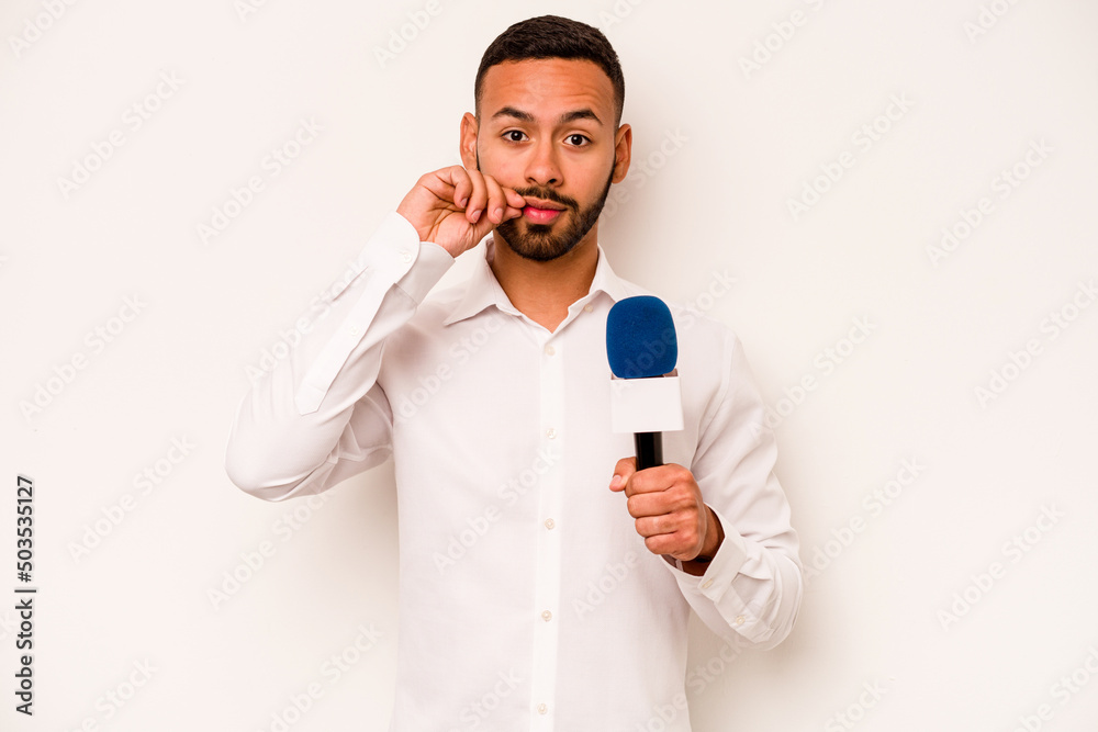 Young hispanic TV presenter isolated on blue background with fingers on lips keeping a secret.
