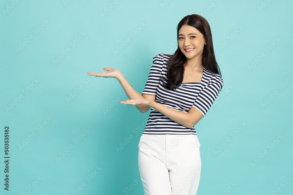 Happy Asian woman open hand palm with copy space for product isolated on green background Happy Asian woman open hand palm with copy space for product isolated on green background