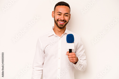 Young hispanic TV presenter isolated on blue background laughing and having fun.