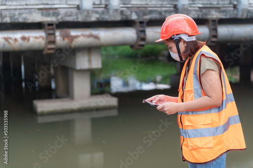 Asian Female engineering working . at sewage treatment plant,Marine biologist analysing water test results,World environment day concept photo